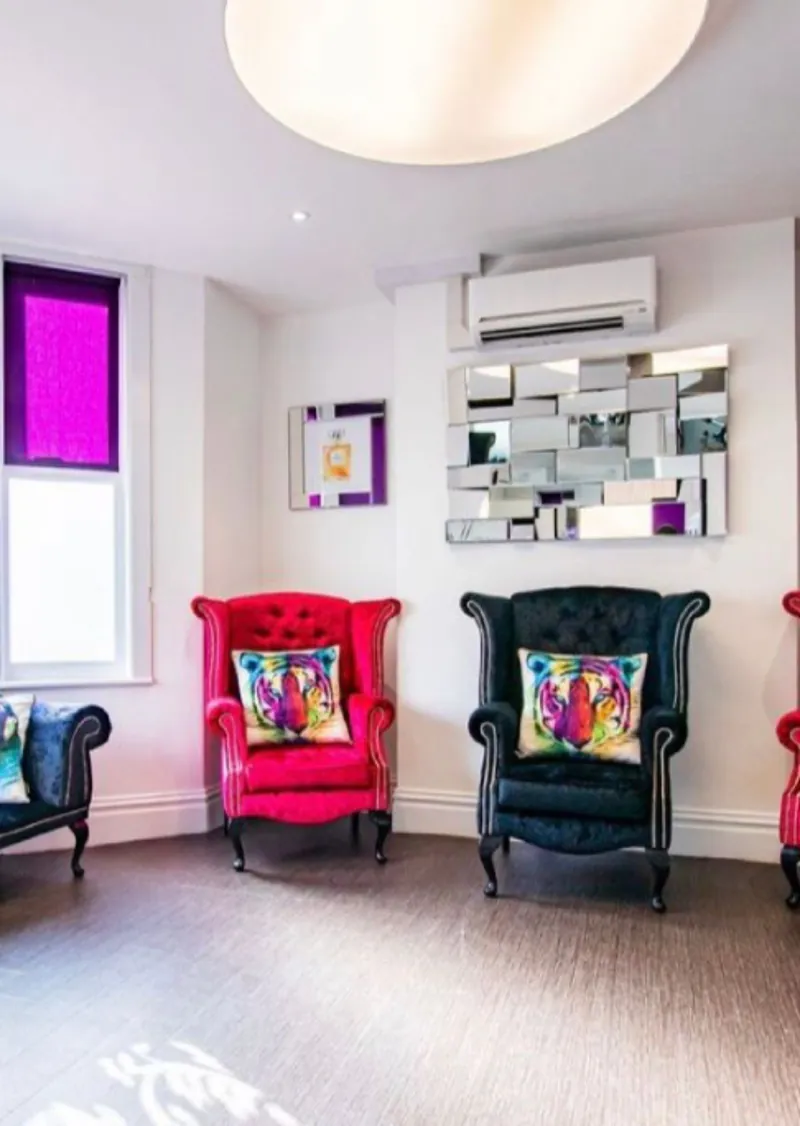 Velvet armchairs and a mirrored wall in the waiting room