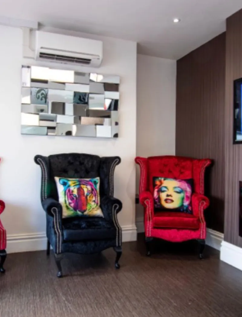 Armchairs beneath a mirrored wall